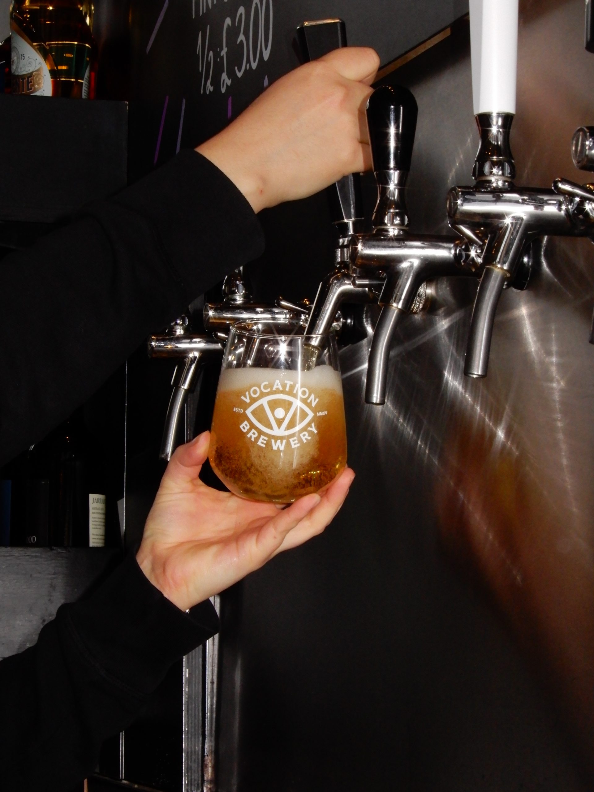 Beer being poured from a Perfect Hive tap into a glass.